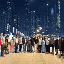 Group of travelers in Dubai with the city’s illuminated skyline, on a Vibha Tours LLP trip.