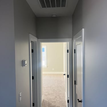 Hallway of new home showing a new thermostat and a return grill  in the ceiling  of a new home in Mount Juliet, TN