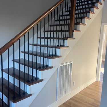 Residential staircase with a large HVAC return vent for optimized airflow and energy-efficient heating and cooling..