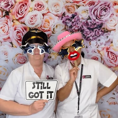 Staff posing in front of the floral fantasy backdrop in their photo booth hire at Victoria Point.
