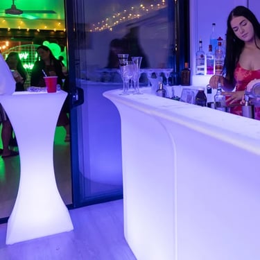 Bartender at the glow bar and guest leaning on the glow cocktail table at vow renewal, Redlands.