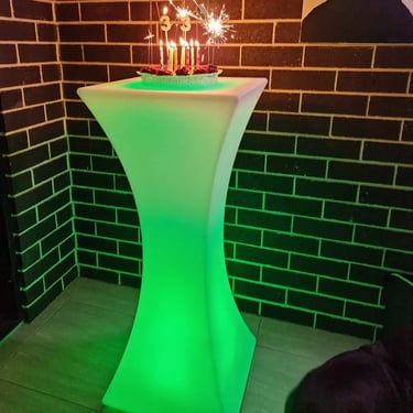 Glowing green cocktail table with cake on top with 33 candles and lit sparklers in Redlands.