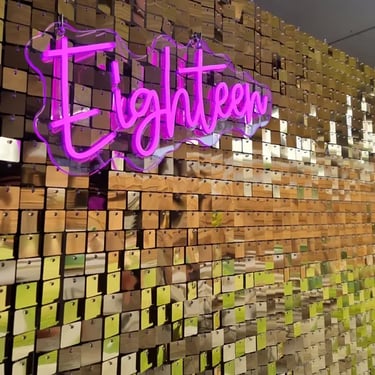 Pink glowing neon Eighteen sign on a gold shimmer wall for Mikayla's 18th birthday in Redland Bay.