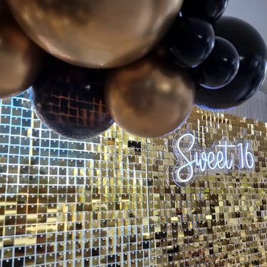 Gold shimmer wall with matching gold and black garland with sweet 16 neon in Brisbane.