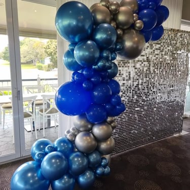 Silver shimmer wall with blue and silver garland for Bev's 70th birthday in Wynnum, Brisbane.