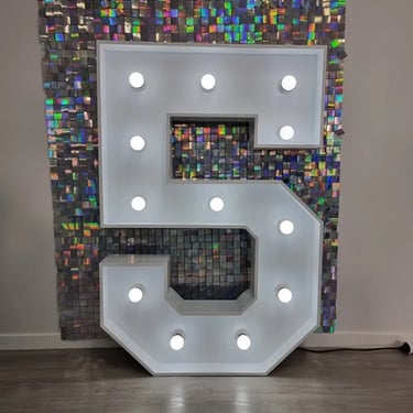 White five marquee number in front of an iridescent shimmer wall in Birkdale.