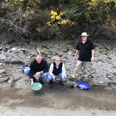 A photograph of a group of people, panning for gold on a river in Central Otago, New Zealand.