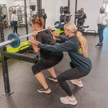 6X coach guiding a member through a personal-training session