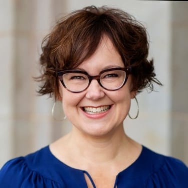 a woman with glasses and a blue blouse