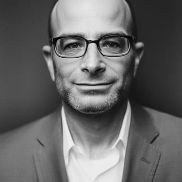 a man in a suit and glasses smiling