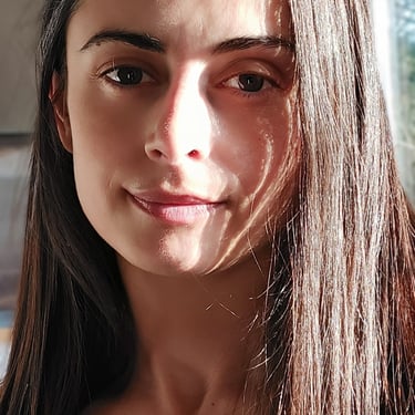 femme trentenaire caucasienne aux cheveux longs qui sourit à la caméra