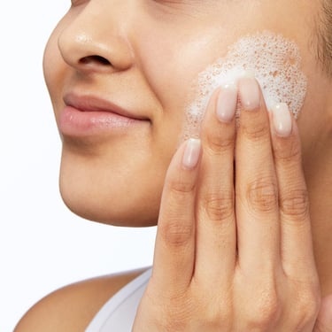 Woman washing face with natural chamomile facial cleanser