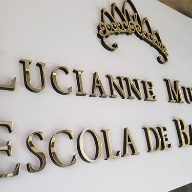 Logotipo em acrílico preto e dourado para parede da recepção