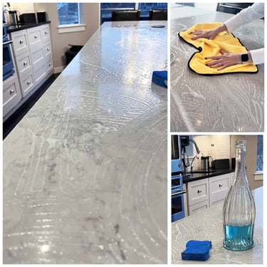 a person cleaning a counter top with a bottle of liquid