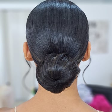 Sleek low bridal bun with a smooth finish for an elegant wedding hairstyle