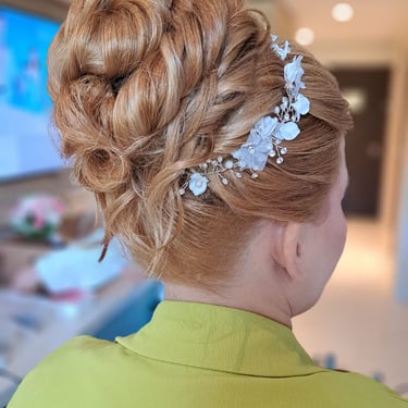 Elegant bridal updo with twisted details and a floral crystal headpiece for a classic wedding look