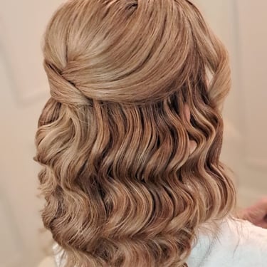 Half-up bridal hairstyle with soft waves and a smooth finish for a simple elegant wedding look