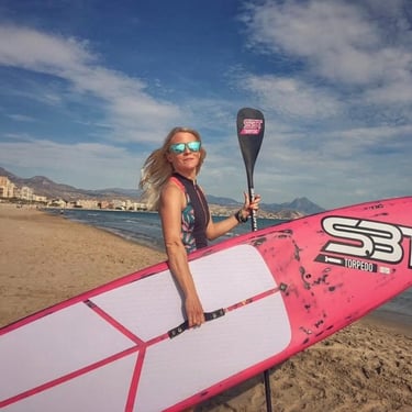 Girl with pink Stand Up Paddle Board going to the water