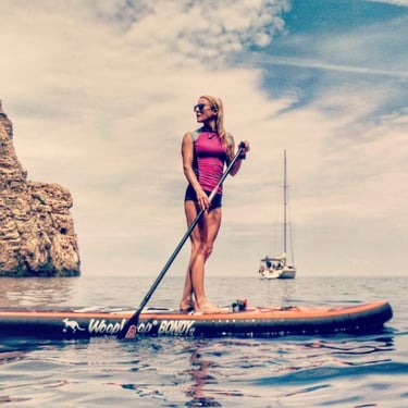Girl on Stand Up Paddle with sailing boat in the backround
