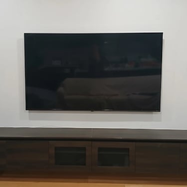 Space-saving ultra slim TV wall mounting for a compact apartment living room in Melbourne CBD.