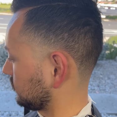 Side profile of a person with a fresh fade haircut and beard.