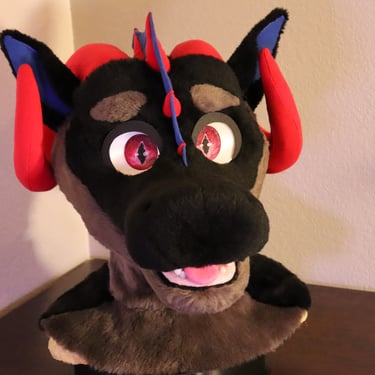 A dragon head made by Teto Creations featuring large curly horns, expressive moving eyelids and silicone teeth