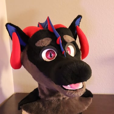 A dragon head made by Teto Creations featuring large curly horns, expressive moving eyelids and silicone teeth