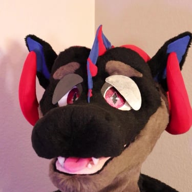 A dragon head made by Teto Creations featuring large curly horns, expressive moving eyelids and silicone teeth