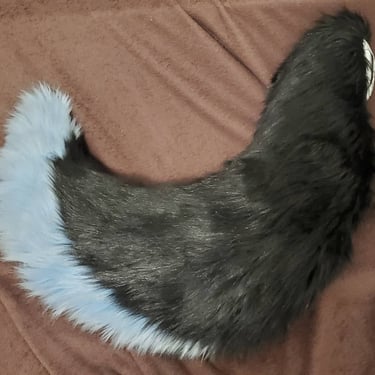 A blue and black fox tail made by Teto Creations