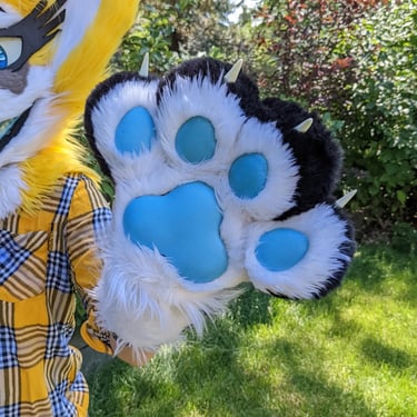A yellow coyote fursuit paws with glowing pads From Teto Creations