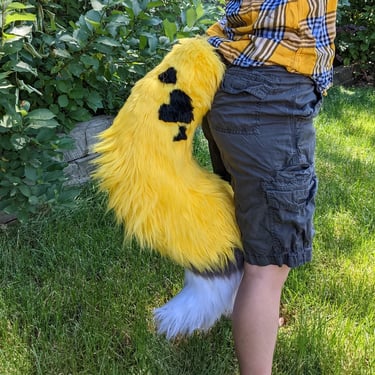 A yellow coyote fursuit tail with hearts From Teto Creations