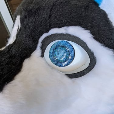 This is blue a dog fursuit made by Teto creations with blue ears and black fur on his face