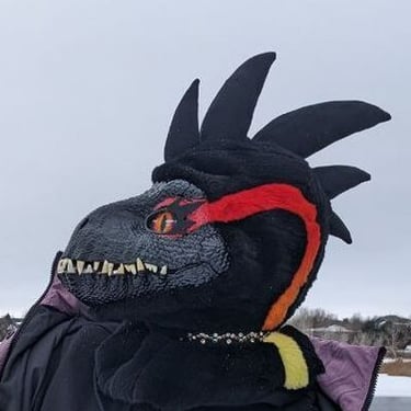 A incorporator fursuit Dino mask made by Teto Creations Featuriong a line of horns, 3d printed eyes and a painted gradient