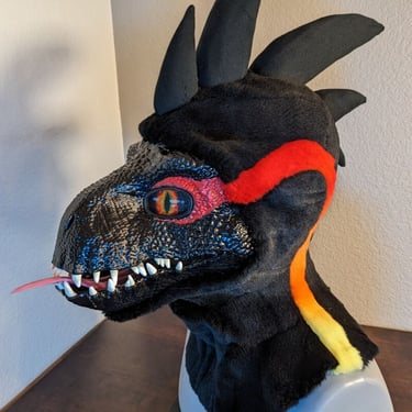 A incorporator fursuit Dino mask made by Teto Creations Featuriong a line of horns, 3d printed eyes and a painted gradient