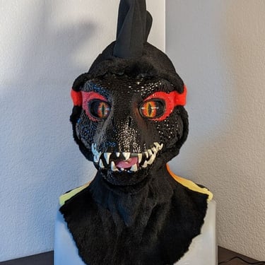 A incorporator fursuit Dino mask made by Teto Creations Featuriong a line of horns, 3d printed eyes and a painted gradient