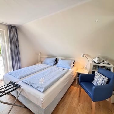 Hotel DunenNest - Balkonzimmer, bequemes Bett und Blick auf den Balkon