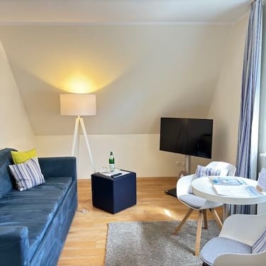 Hotel DunenNest - Kleine Suite, Wohnzimmer, Sofa, Sitzecke mit Tisch