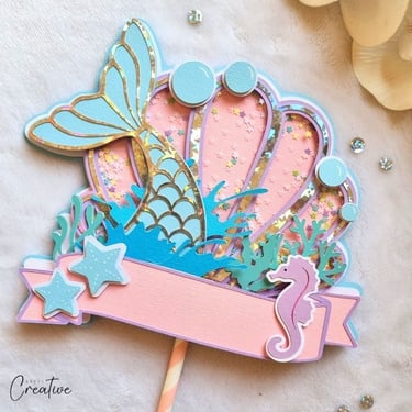 Pastel colors cake topper with a shape of a shell and mermaid tail