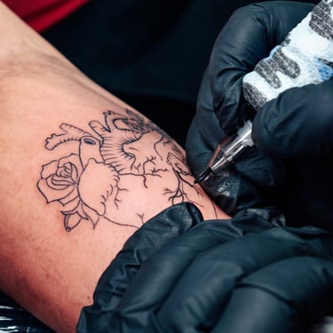 hombre tatuandose corazon ace tattoo studio