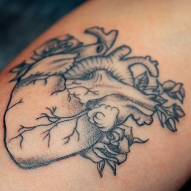 tatuaje blanco y negro corazon con flores y ramas