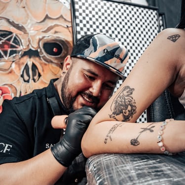 hombre tatuando a mujer en ace tattoo studio quito