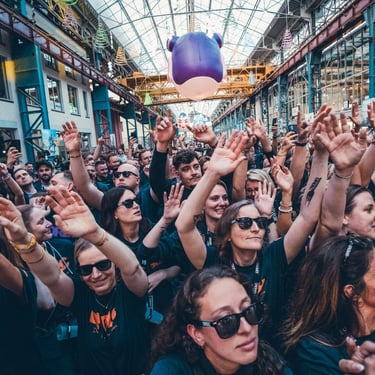 Une foule avec des lunettes de soleil les bras levés