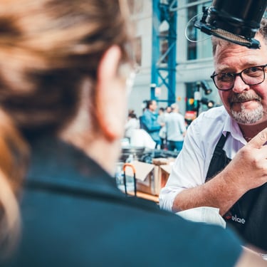 homme à lunettes faisant un signe de la main