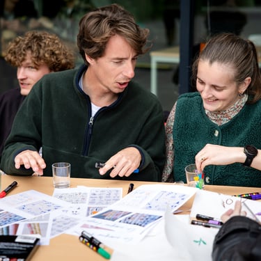 Un ensemble de personnes assises autour d'une table et travaillant sur des exercices écrits