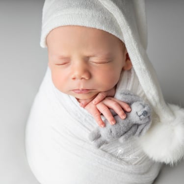 Recién nacido dormido con envoltura y gorrito
