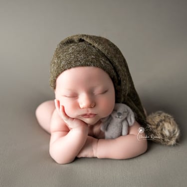recién nacido durmiendo con muñeco y gorrito dormilón
