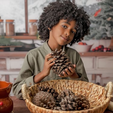 niño sosteniendo piñas con una cesta
