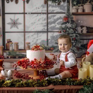 bebé al lado de una tarta con osito de navidad con gorro de papá noel
