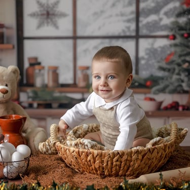 bebé sentado en cesta con huevos al lado y árbol de navidad al fondo