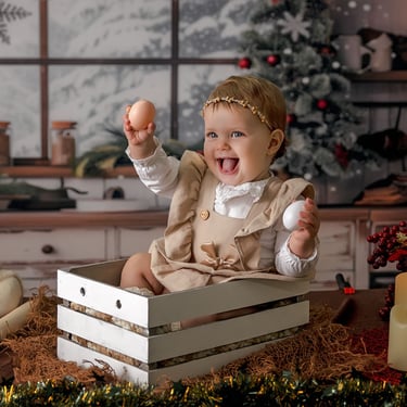 fotografía de navidad con una bebé en una cajita